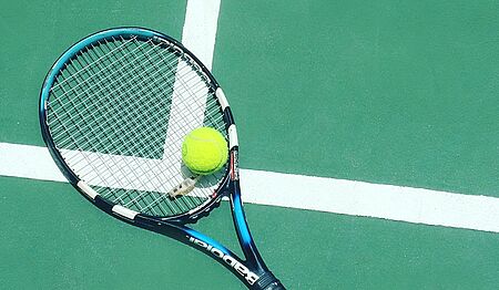 Tennisplatz mit Racket und Ball am Boden liegend